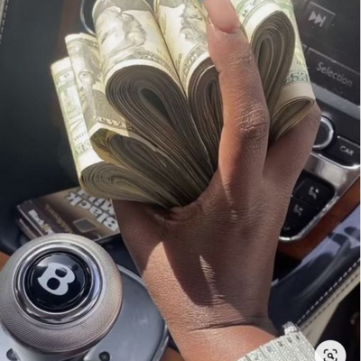 black hand holding stack of money
